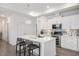 Bright kitchen boasts white cabinets, stainless appliances, an island with bar seating, and stylish backsplash at 1206 Linkwood Way, Fuquay Varina, NC 27526