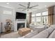 Cozy living room with a fireplace, mounted TV, ample seating, and large windows overlooking the backyard at 1206 Linkwood Way, Fuquay Varina, NC 27526
