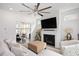 Comfortable living room with a fireplace, flatscreen tv, large windows, and views of the outdoor patio at 1206 Linkwood Way, Fuquay Varina, NC 27526