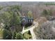 Aerial view showcasing a well-maintained brick home with mature trees and a winding driveway at 12101 Lockhart Ln, Raleigh, NC 27614