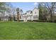 Expansive backyard featuring lush green grass and a white house with a patio at 12101 Lockhart Ln, Raleigh, NC 27614