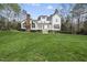 Expansive backyard featuring lush green grass and a white house with a patio at 12101 Lockhart Ln, Raleigh, NC 27614