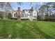Expansive backyard featuring lush green grass and a white house with a patio at 12101 Lockhart Ln, Raleigh, NC 27614