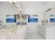 Bright bathroom with white tile, and white cabinets with dual sinks and gold fixtures at 12101 Lockhart Ln, Raleigh, NC 27614