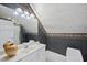 Attic bathroom with wallpaper, white vanity, sink, and shower with glass doors at 12101 Lockhart Ln, Raleigh, NC 27614