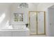 Bright bathroom with white tile, glass shower, and large garden tub with jacuzzi jets at 12101 Lockhart Ln, Raleigh, NC 27614