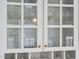White cabinet showcasing glassware with glass doors and brass hardware below counter for bottles at 12101 Lockhart Ln, Raleigh, NC 27614