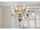 Ornate gold chandelier with decorative molding and window accentuates the elegance of the room at 12101 Lockhart Ln, Raleigh, NC 27614