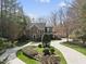 Beautiful brick home featuring mature trees, landscaping, and a circular driveway at 12101 Lockhart Ln, Raleigh, NC 27614