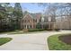 Charming brick home with a well-manicured lawn, mature shrubs, and classic architectural details at 12101 Lockhart Ln, Raleigh, NC 27614