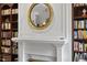 Close up of a fireplace with round mirror and built-in bookshelves at 12101 Lockhart Ln, Raleigh, NC 27614