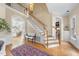 Grand foyer with hardwood floors, staircase, decorative rug, and view into the kitchen at 12101 Lockhart Ln, Raleigh, NC 27614