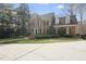 Elegant brick home featuring a well-maintained lawn and mature trees, creating a private setting at 12101 Lockhart Ln, Raleigh, NC 27614