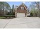 Attached garage with a wide driveway surrounded by mature trees and lush landscaping at 12101 Lockhart Ln, Raleigh, NC 27614