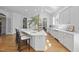 Bright kitchen featuring white cabinets, countertops, and a large island with seating for three at 12101 Lockhart Ln, Raleigh, NC 27614