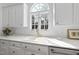 Bright kitchen featuring white cabinets and countertops, a brass faucet, and a window at 12101 Lockhart Ln, Raleigh, NC 27614