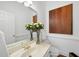 Bright powder room featuring a decorative mirror, art and a large bouquet of yellow roses at 12101 Lockhart Ln, Raleigh, NC 27614