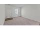 A living room features neutral carpet, a window, and a white door at 127 N Keatts Winner Ct, Wilson's Mills, NC 27520