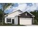 Charming single-story home featuring a two-car garage, white siding, and a well-maintained lawn at 135 N Keatts Winner Ct, Clayton, NC 27520