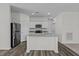 Modern kitchen with white cabinets, a granite countertop island, stainless steel appliances, and luxury vinyl plank flooring at 135 N Keatts Winner Ct, Clayton, NC 27520