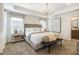 Inviting bedroom boasts a tray ceiling with modern light fixture, and neutral colors throughout at 1411 Chrysalis Pl, Apex, NC 27502