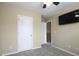 A cozy bedroom boasts a mounted TV and adjoining door, freshly painted and carpeted at 1536 Ricochet Dr, Raleigh, NC 27610