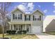 Charming two-story home with gray siding, a covered front porch, attached garage and a well-maintained front yard at 1536 Ricochet Dr, Raleigh, NC 27610