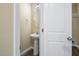 Cozy powder room featuring a pedestal sink, modern lighting, and new wood flooring at 1536 Ricochet Dr, Raleigh, NC 27610