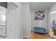 Hallway with hardwood floors, a blue storage bench, and white closets with brass pulls at 1603 N Alston Ave, Durham, NC 27701