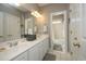 Bright bathroom features double sinks, white cabinets, and a doorway to the shower and tub at 1705 Mcrae Pl, Hillsborough, NC 27278