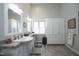 This bathroom offers double sinks, bright white cabinets, and tile floors at 1705 Mcrae Pl, Hillsborough, NC 27278