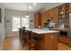 Bright eat-in kitchen features wood cabinets, stainless appliances, and a center island with seating at 1705 Mcrae Pl, Hillsborough, NC 27278