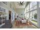 A bright sunroom with large windows, tile floors, and a ceiling fan at 1705 Mcrae Pl, Hillsborough, NC 27278