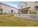 Well-maintained backyard with green grass, a white picket fence, and a covered patio area at 200 Mariah Towns Way, Garner, NC 27529