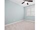 A simple, light-blue bedroom features neutral carpet, a ceiling fan, and a window providing natural light at 200 Mariah Towns Way, Garner, NC 27529