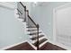 A staircase with wood steps and a dark metal railing with white walls at 200 Mariah Towns Way, Garner, NC 27529