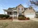 Inviting two-story home showcasing a well-manicured lawn, classic siding, and a welcoming covered front porch at 2012 Castana Ct, Willow Springs, NC 27592