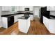 A kitchen featuring white cabinetry, black countertops, stainless steel appliances, and hardwood floors at 2012 Castana Ct, Willow Springs, NC 27592