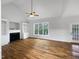 Bright living room featuring a fireplace, built-in shelving, large window, and hardwood floors at 2012 Castana Ct, Willow Springs, NC 27592