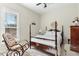 Bright bedroom featuring a four-poster bed, comfortable chair, and lots of natural light at 203 Streamside Dr, Sanford, NC 27330