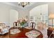 Elegant dining room featuring a round table with floral arrangements, hardwood floors, and abundant natural light at 203 Streamside Dr, Sanford, NC 27330