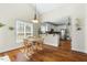 Bright breakfast nook with wood floors and an open view into the kitchen with white cabinetry and stainless appliances at 203 Streamside Dr, Sanford, NC 27330