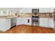 Well-equipped kitchen with stainless steel appliances, tile backsplash, granite countertops, and wood floors at 203 Streamside Dr, Sanford, NC 27330