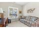 Comfortable living room with a large window, desk, and floral sofa for relaxing or working at 203 Streamside Dr, Sanford, NC 27330