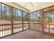 Cozy screened porch with wood flooring, ceiling fan, and views of the wooded backyard at 203 Streamside Dr, Sanford, NC 27330