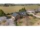Aerial view of a brick home with a dark roof, surrounded by lush greenery and an adjacent field at 205 Parliament Pl, Dunn, NC 28334