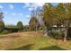Large backyard with patio, bench, mature trees and landscaping, creating a peaceful outdoor space at 205 Parliament Pl, Dunn, NC 28334