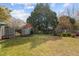 The backyard features a large grassy area with mature trees and a fenced perimeter at 205 Parliament Pl, Dunn, NC 28334