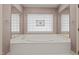 This bathroom showcases a large soaking tub with tiled surround and stained glass window at 205 Parliament Pl, Dunn, NC 28334