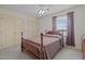 Cozy bedroom features a wood frame bed, ceiling fan, and natural light from the window at 205 Parliament Pl, Dunn, NC 28334